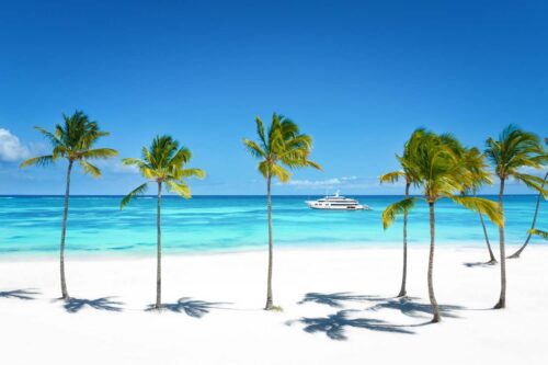 Bahamas charter yacht TOP FIVE II, a 200 foot Royal Hakvoort yacht cruising just off the beach.