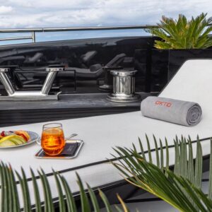 Sundeck of OKTO 218, a 218 foot ISA yacht for charter in the Mediterranean in the background.