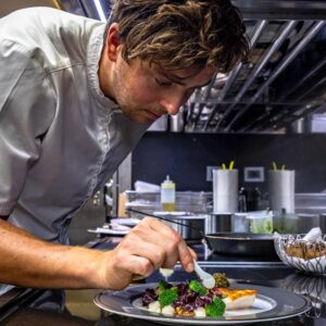 Chef preparing a meal aboard OKTO, a 218 foot ISA yacht for charter in the Mediterranean.