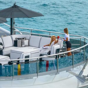 Sundeck of OKTO, a 218 foot ISA yacht for charter in the Mediterranean in the background.