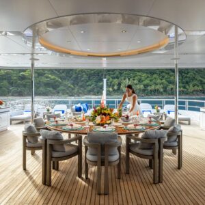 Outdoor dining aboard TOP FIVE II, a 200-foot Royal Hakvoort yacht for charter in The Bahamas and Caribbean.