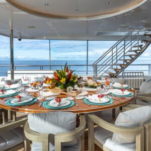 Outdoor dining aboard TOP FIVE II, a 200-foot Royal Hakvoort yacht for charter in The Bahamas and Caribbean.