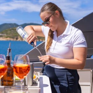Chief stewardess making a cocktail aboard SWEET VIRGINIA, a 96′ Sanlorenzo yacht for charter in The Bahamas.