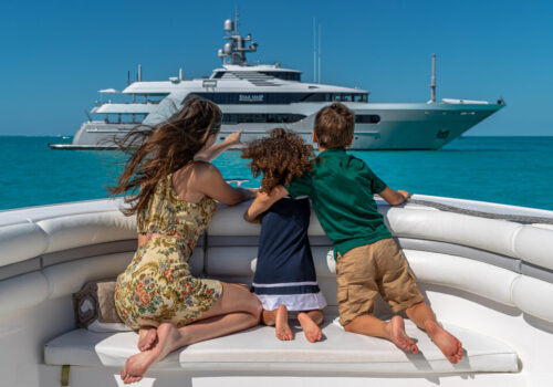 Charter yacht guests observing the motor yacht for charter STARSHIP. A family enjoying the water toys on a family yacht charter. Family yacht charters offer parallel adventures that foster connection, independence, and fun for the whole family.