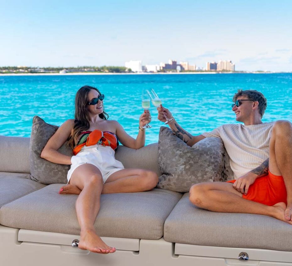 Couple lounging on PLAYTIME, a 64 foot Lagoon yacht for charter in The Bahamas.